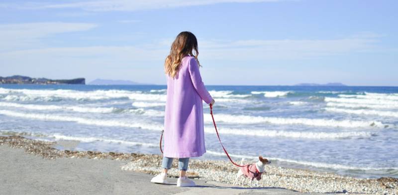 Ragazza con cane sulla spiaggia in inverno